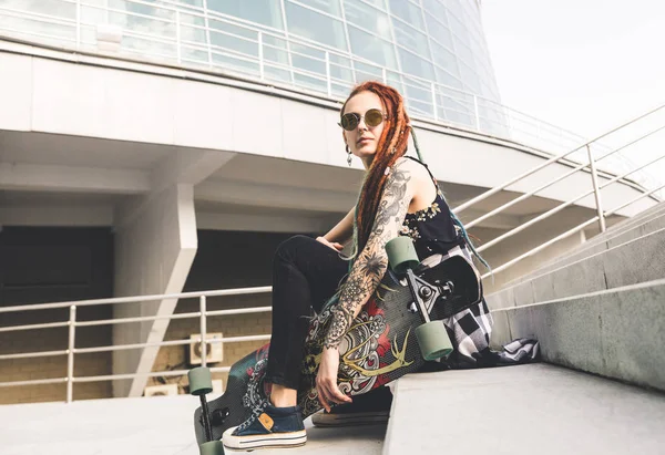 UFA, RUSIA - 12 de septiembre de 2018 Foto editorial de una joven con tatuaje y rastas sentada en las escaleras —  Fotos de Stock