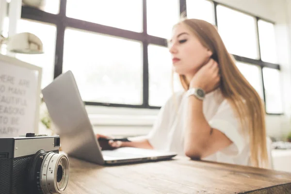 Joven mujer de negocios trabajando en casa detrás de un portátil. Espacio de trabajo de estilo escandinavo creativo — Foto de Stock