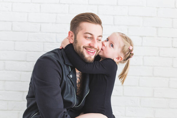 Cute little girl and her dad are having fun at home.