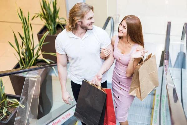 Bonito jovem casal amoroso europeu carregando sacos de compras e desfrutando juntos . — Fotografia de Stock