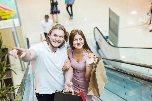 Bonito jovem casal amoroso europeu carregando sacos de compras e desfrutando juntos . — Fotografia de Stock