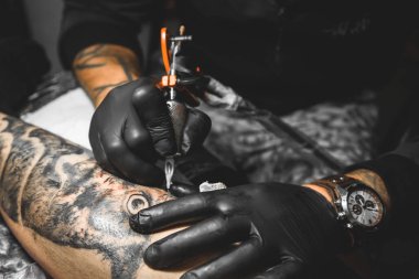 Dövme sanatçısı bir adamın vücudunda bir resim oluşturur. dövme makineleri ve elleri yakın çekim