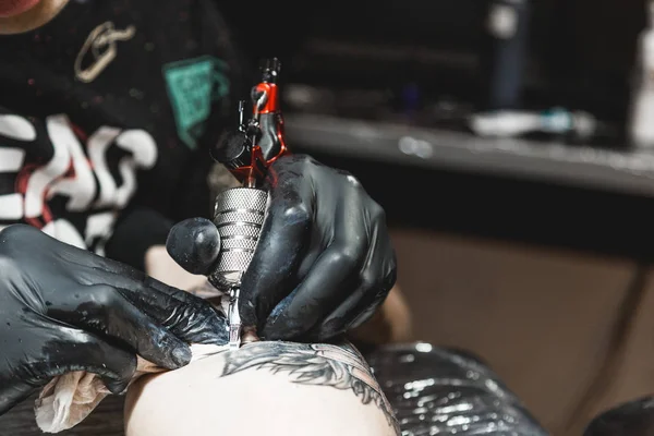Dövme sanatçısı bir adamın vücudunda bir resim oluşturur. dövme makineleri ve elleri yakın çekim — Stok fotoğraf