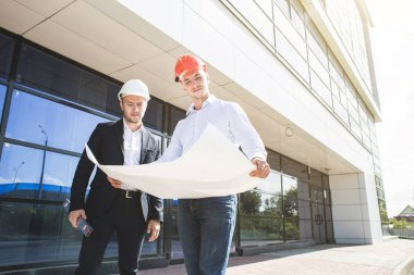 bir mühendis ve şantiye planı kontrol alt görünümü