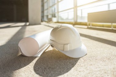 beyaz kask, bir inşaat alanında bir pencere arka plan üzerinde bir bina planları