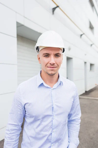 Ingeniero masculino en casco en el fondo del edificio — Foto de Stock