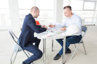 Erkek mühendisler tablo ile bir dizüstü bilgisayar, iş görüşmeleri inşaat alanındaki çalışma yapanlar. pazarlık, daire satın alma, gayrimenkul
