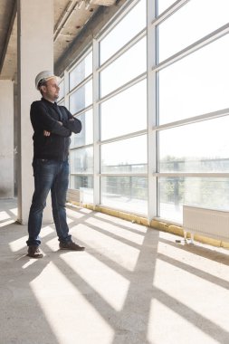 çizimleri ile bir kask içinde builder mimar inşaat alanında çalışıyor. inşaat gözetimi.