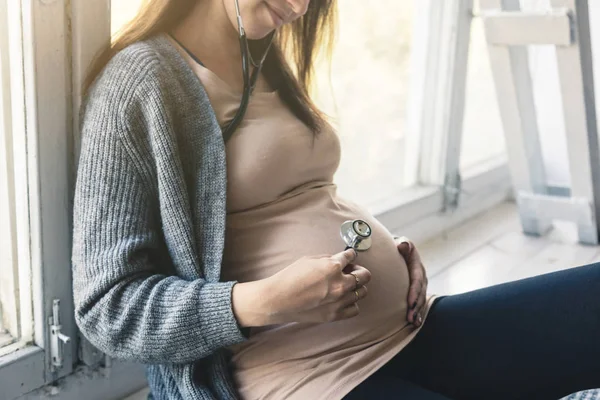 Schwangerschaft, Gynäkologie, Medizin, Gesundheitswesen und Menschen-Konzept - Stethoskop hört Schwangeren zu — Stockfoto