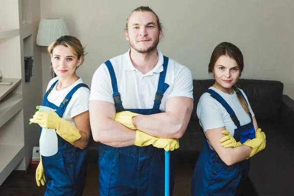 Reinigungsservice mit professionellem Gerät während der Arbeit. Professionelle Küchenreinigung, Sofa-Trockenreinigung, Fenster- und Fußbodenwäsche. Männer und Frauen in Uniform, Overalls und Gummihandschuhen — Stockfoto