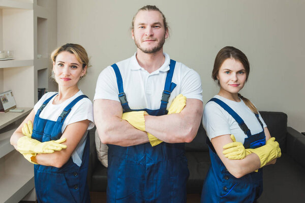 Cleaning service with professional equipment during work. professional kitchenette cleaning, sofa dry cleaning, window and floor washing. man and women in uniform, overalls and rubber gloves