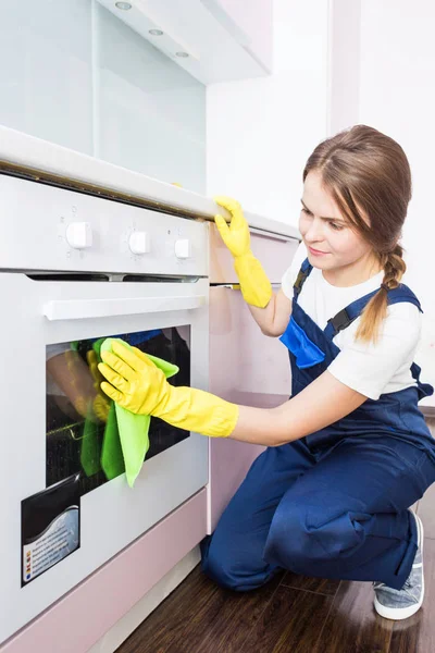 Sprzątanie z profesjonalnym sprzętem podczas pracy. profesjonalne sprzątanie aneksem kuchennym, suszarka do kanapy, mycie okien i podłóg. mężczyźni i kobiety w mundurach, kombinezonach i gumowych rękawiczkach — Zdjęcie stockowe