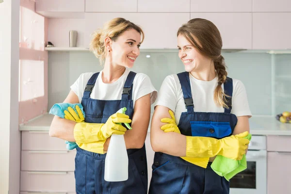 Serviço de limpeza com equipamento profissional durante o trabalho. limpeza kitchenette profissional, sofá limpeza a seco, janela e lavagem de piso. homem e mulher de uniforme, macacão e luvas de borracha — Fotografia de Stock