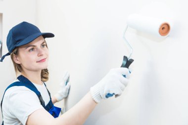 güzel kadın profesyonel olarak odanın duvarları boya. insanlar üniformalı, Tulum ve bir kap bir rulo ve fırça, daire tadilat, dekorasyon, beceremedim. izole