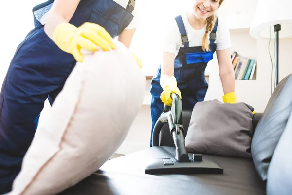 Servicio de limpieza con equipo profesional durante el trabajo. limpieza profesional de la cocina, limpieza en seco del sofá, lavado de ventanas y suelos. hombres y mujeres en uniforme, monos y guantes de goma — Foto de Stock