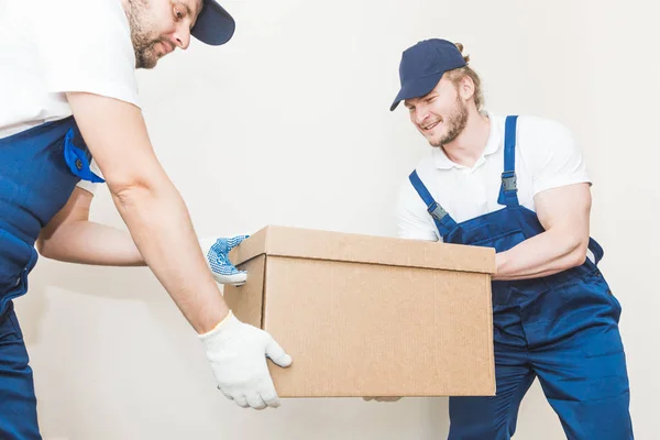 Uomo di consegna che carica scatole di cartone per trasferirsi in un appartamento. lavoratore professionista del trasporto, caricatori maschili in tuta intera — Foto Stock