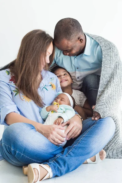 El padre amoroso cubre a su familia con una manta a cuadros. Feliz familia multiétnica. Valores familiares — Foto de Stock