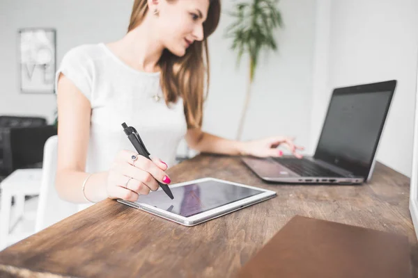 Joven mujer de negocios que trabaja en casa y se basa en la tableta. Espacio de trabajo de estilo escandinavo creativo — Foto de Stock