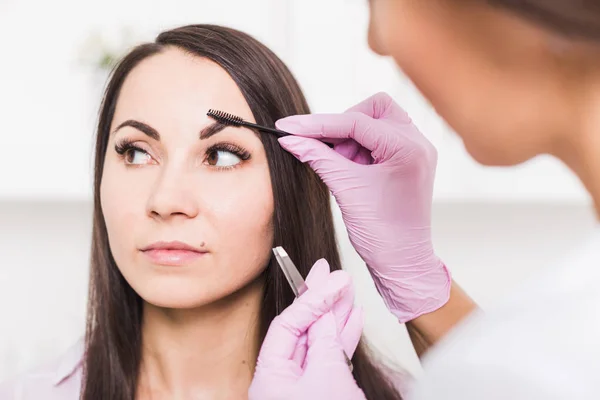 Beautiful young woman gets eyebrow correction procedure — Stock Photo, Image