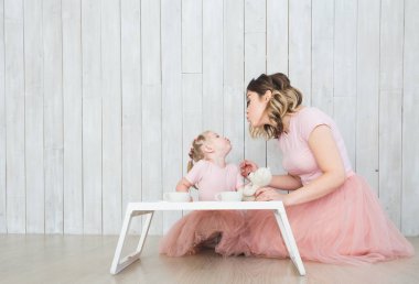 Anne ile kızı beyaz bir arka plan üzerinde aynı giysileri