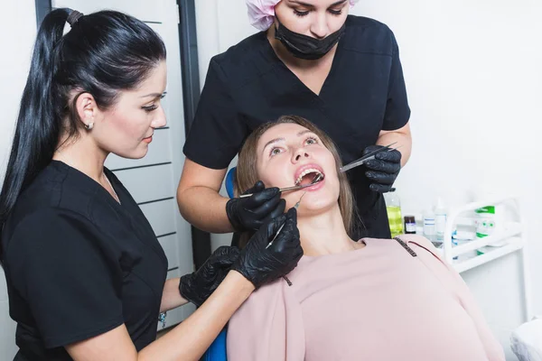 Dental clinic. Reception, examination of the patient. Teeth care. Young woman undergoes a dental examination by a dentist