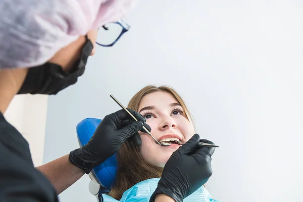Dental clinic. Reception, examination of the patient. Teeth care. Young girl undergoes a dental examination by a dentist