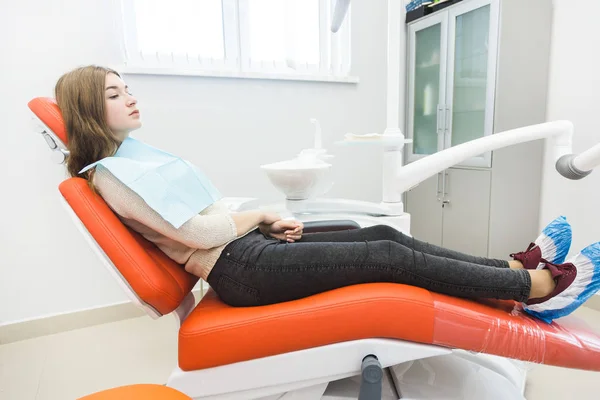 Clínica dental. Recepción, examen del paciente. Cuidado de los dientes. La chica está sentada en la silla dental lista para examinar los dientes. — Foto de Stock