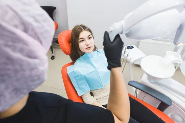 Clínica dentária. Recepção, exame do paciente. Cuidado com os dentes. Dentista feminina em consultório odontológico conversando com paciente menina . — Fotografia de Stock