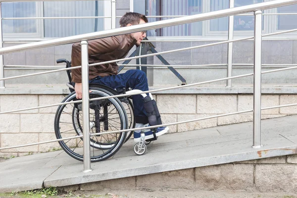 Muž na invalidním vozíku slouží Bezbariérový. — Stock fotografie