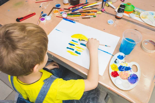 Mały chłopiec z nauczycielem w grupie przedszkolaka usiadł rysunek obraz. Malowanie na maelberze, paleta i farby. Koncepcja powrotu do szkoły i edukacji — Zdjęcie stockowe