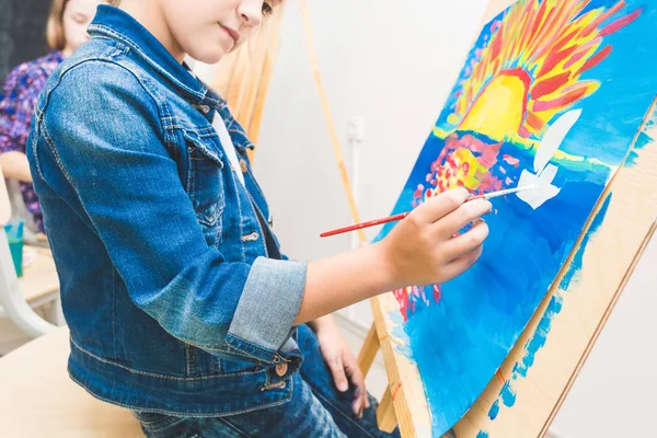 Dziewczynka z nauczycielem w grupie uczeń przedszkola rysunek obraz. Malowanie na maelberze, paleta i farby. Koncepcja powrotu do szkoły i edukacji. — Zdjęcie stockowe