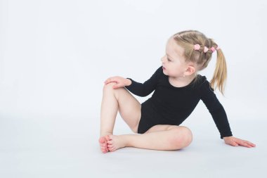 Sevimli küçük kız beyaz zemin katta oturan güzel siyah elbiseli.