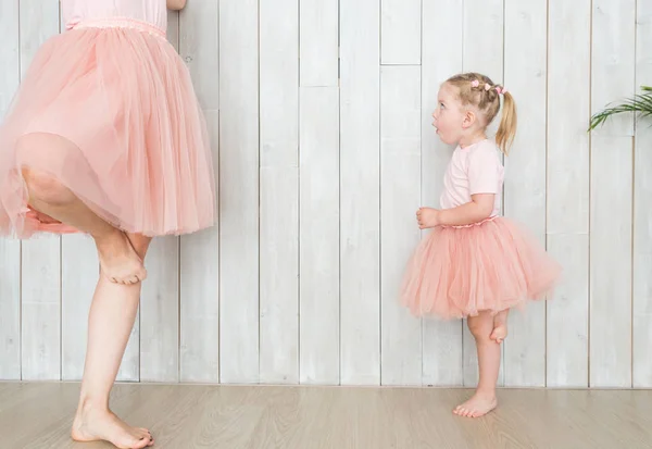 Mamá con su hija en la misma ropa sobre un fondo blanco . — Foto de Stock