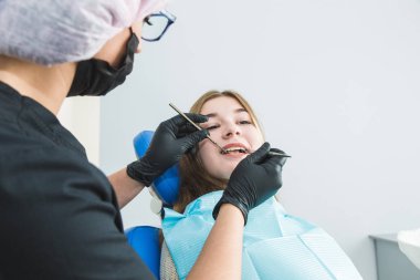 Diş sağlığı kliniği. Resepsiyon, hastanın muayenesi. Diş bakımı. Genç kız bir diş hekimi tarafından muayene ediliyor.