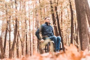 Genç biri tekerlekli sandalyede park yol boyunca rides.
