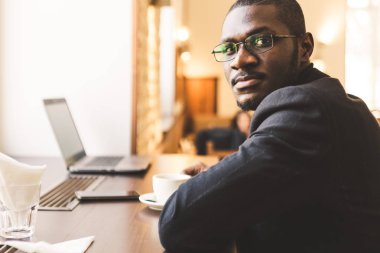Bir fincan çay ile bir kafede genç yakışıklı Dark-skinned işadamı.