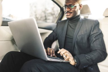Bir iş kıyafeti adam deri iç ile pahalı bir araba salonda laptop yazmak.