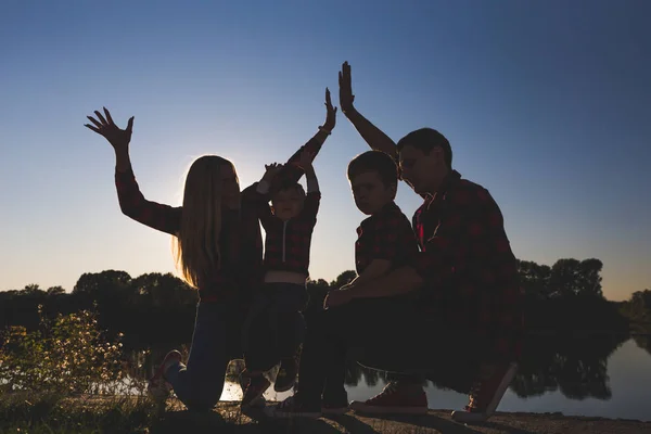 stock image Young happy family with childrens having fun in nature. Parents walk with children in the park