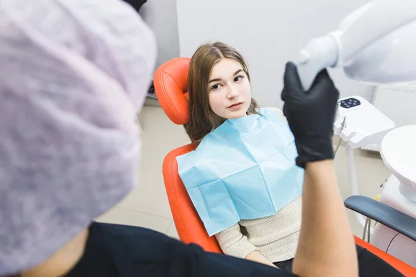 Clínica dental. Recepción, examen del paciente. Cuidado de los dientes. Dentista femenina en consultorio dental hablando con paciente chica . —  Fotos de Stock