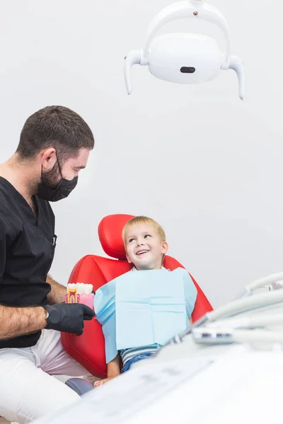 Dental clinic. Reception, examination of the patient. Teeth care. Male dentist in dental office talking with patient