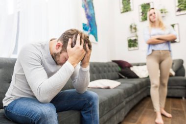 Mutsuz genç çift oturma odasında tartışıyor.