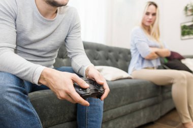 Bir adam elinde bir gamepad tutar, bir hoşnutsuz kız onların yanında oturur, onlar kavga.