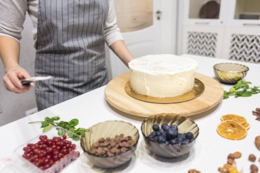 Şekerleme spatulası ile bisküvi pastası üzerine beyaz krema. Ev yapımı hamur işi, kek pişirme....