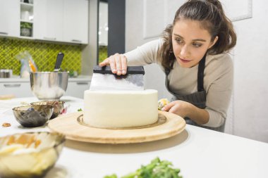 Şekerleme spatulası ile bisküvi pastası üzerine beyaz krema. Ev yapımı hamur işi, kek pişirme....