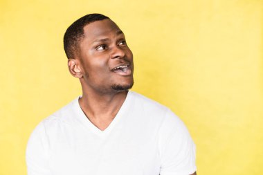 Sarı bir arka planda genç bir yakışıklı sürpriz adam portre.