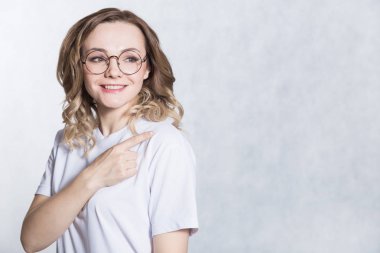 Yakışıklı genç kadın boş kopya uzayda önefinger ile gösterir.