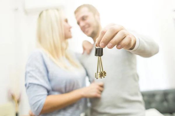 Una encantadora pareja joven tiene delante de ellos las llaves de su nuevo apartamento . — Foto de Stock