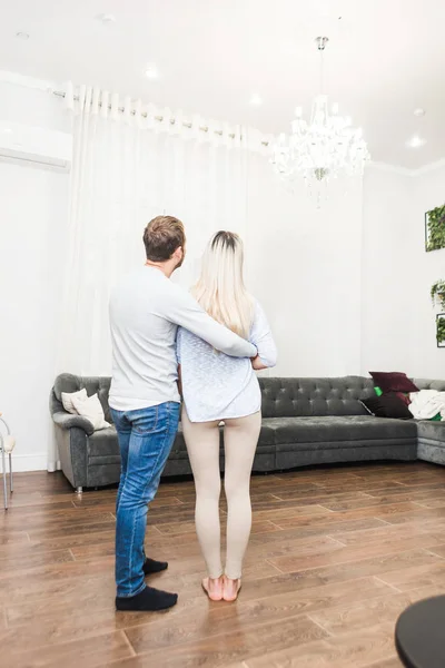 Encantador jovem casal em uma sala de estar com um interior moderno . — Fotografia de Stock