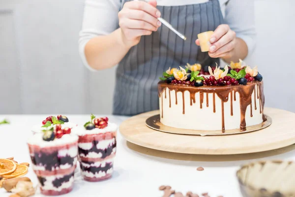 Decorazione del dessert finito. Pasticcere spruzza dolciumi con polvere gialla. Il concetto di pasticceria fatta in casa, torte di cottura . — Foto Stock