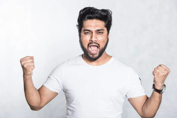 Retrato del hombre alegre aprieta los puños con felicidad, posa sobre fondo blanco . —  Fotos de Stock